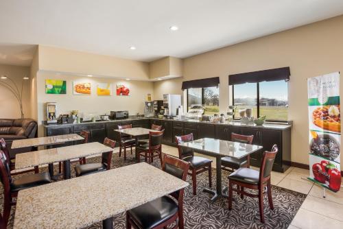 a restaurant with tables and chairs and a kitchen at Quality Inn & Suites Caseyville - St Louis in Caseyville