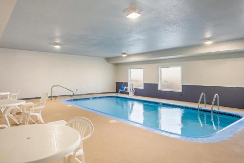 a large pool in a room with tables and chairs at Quality Inn & Suites Caseyville - St Louis in Caseyville