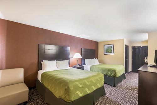 a hotel room with two beds and a television at Quality Inn & Suites Caseyville - St Louis in Caseyville