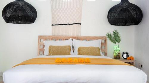 um quarto com uma cama com flores de laranja em Villa Beji Ayu em Seminyak