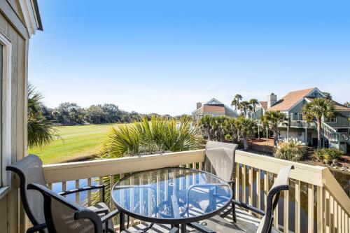 eine Terrasse mit Tisch und Stühlen auf einem Balkon in der Unterkunft Sealoft 941 in Seabrook Island