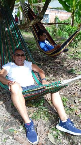 two men sitting in hammocks in a park at HOSTAL CASA VICTORIA PIJAO in Pijao