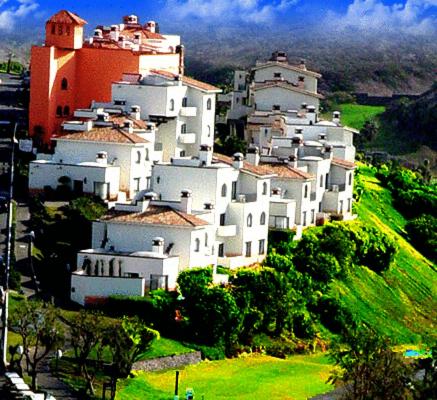 a group of white buildings on a hill at Real del Mar Golf Resort in Tijuana