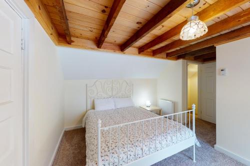 een slaapkamer met een bed en een houten plafond bij Pleasant Condos in Ludlow