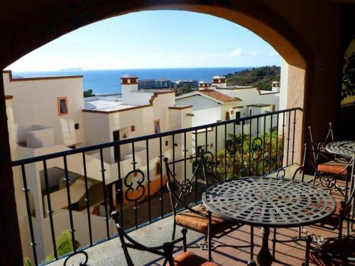 a balcony with a table and chairs and the ocean at Real del Mar Golf Resort in Tijuana