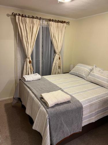 1 dormitorio con 1 cama con 2 toallas en Apart hotel Chillan - Full house - Ohiggins - Empresas- Factura - Parking en Chillán
