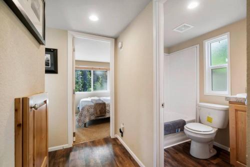 a bathroom with a toilet and a room with a bed at New Tiny Home Steps Away From Mt. Rainier in Ashford