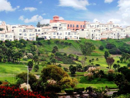 a large white building on top of a green hill at Real del Mar Golf Resort in Tijuana