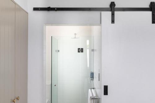 a bathroom with a shower with a glass door at The Clovelly Hotel in Sydney