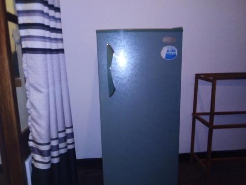 a blue refrigerator in a room next to a wall at Villa Maleena in Hikkaduwa