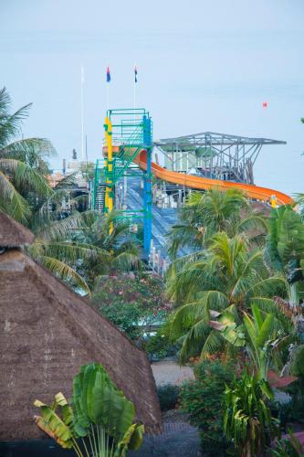 an orange and blue train in a garden with palm trees at Rawa Island Resort in Mersing