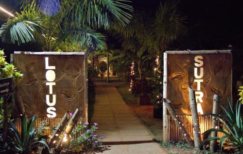 a gate with the words welcome to a garden at night at Lotus Sutra in Arambol