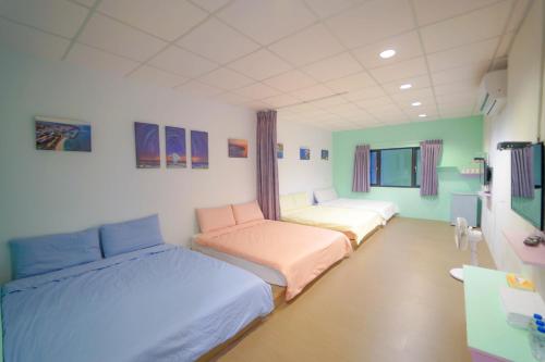 um quarto com 2 camas e uma secretária em Chen Je B&B em Xiaoliuqiu