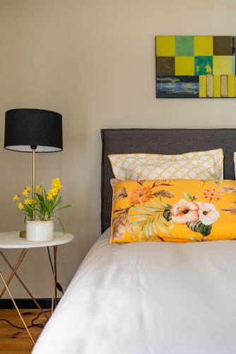 a bed with a yellow pillow and a table with a lamp at Domaine de la Serve in Lancié