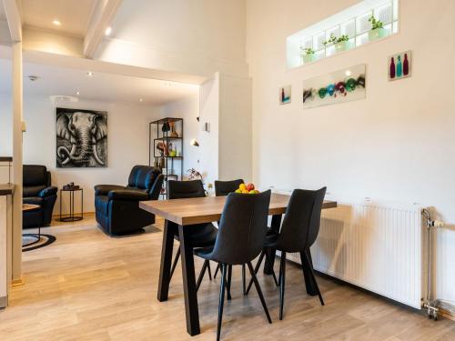 - une salle à manger et un salon avec une table et des chaises dans l'établissement Restful Holiday home in Herselt with Garden, à Herselt