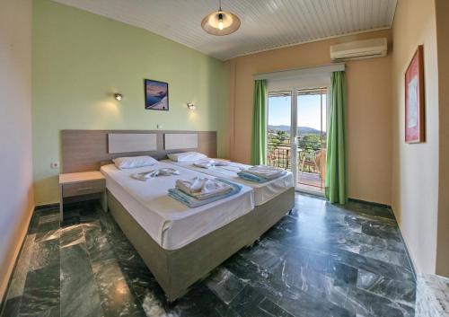 a bedroom with a large bed and a balcony at Armonia Studios in Anaxos