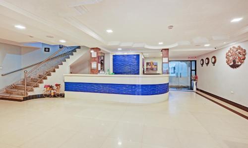 a large lobby with a blue and white wall at Treebo Sidhartha International Baliapanda in Puri