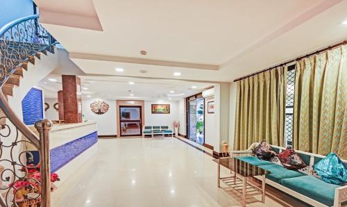 a living room with a couch and a staircase at Treebo Sidhartha International Baliapanda in Puri