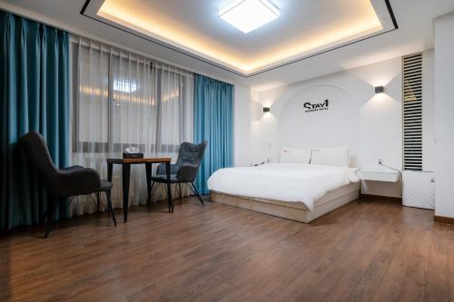 a hotel room with a bed and a table and chairs at Stay Hotel in Gwangju