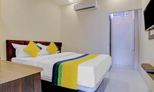 Un dormitorio con una cama con una manta de colores. en Hotel Anand Shree,Indore, en Indore