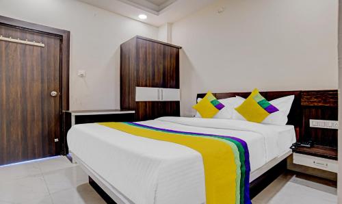 - une chambre avec un grand lit blanc et des oreillers colorés dans l'établissement Hotel Anand Shree,Indore, à Indore