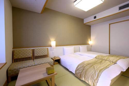 a bedroom with a bed and a table and a bench at Oyado Tsukiyo no Usagi in Izumo