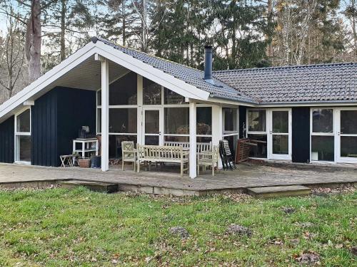a house with a porch with a bench on a deck at 6 person holiday home in Vejby-By Traum in Vejby