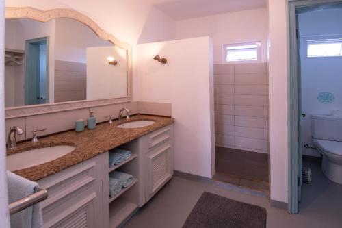 a bathroom with two sinks and a mirror at Le Mandala Moris in Pointe aux Cannoniers