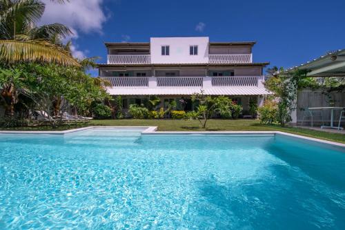 a house with a swimming pool in front of a house at Le Mandala Moris in Pointe aux Canonniers