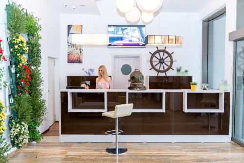 a woman sitting at a desk in a room at Hotel On Plonge Junior in Mamaia