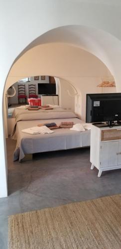 a bedroom with two beds and a flat screen tv at Scauribasso14 in Pantelleria