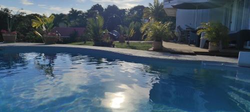 a swimming pool with blue water in a yard at Un coin de paradis, piscine privative, vue Saintes in Trois-Rivières