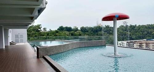 a swimming pool with a red umbrella on a building at 4A Icon Residence in Kuala Terengganu