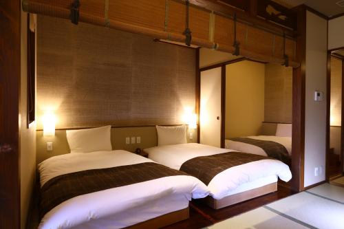 two beds in a room with twothirds at Inishie no Yado Keiun in Izumo