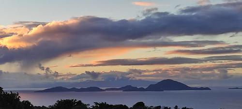 a sunset over a body of water with mountains at Un coin de paradis, piscine privative, vue Saintes in Trois-Rivières