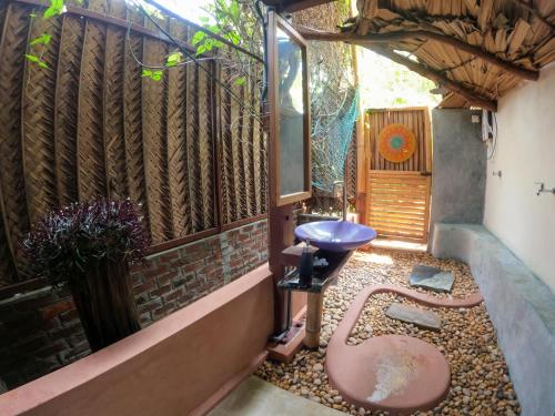 a small courtyard with a bench and a stool at Monsoon Eco Resort - Whisky point Arugambay in Pottuvil