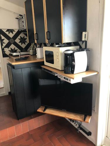 une cuisine avec un comptoir avec un micro-ondes dessus dans l'établissement La Bonbonnière, un havre de paix, à Fréjus