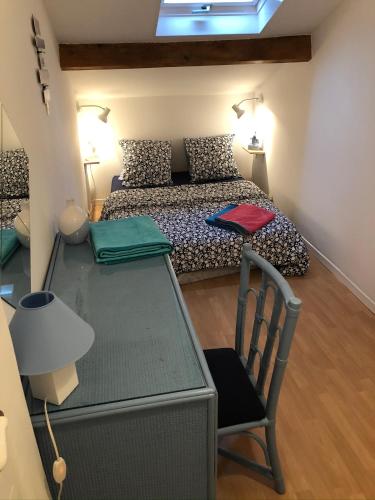 une chambre avec un lit et une table avec une chaise dans l'établissement La Bonbonnière, un havre de paix, à Fréjus