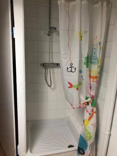 une douche avec un rideau de douche dans une salle de bain dans l'établissement La Bonbonnière, un havre de paix, à Fréjus