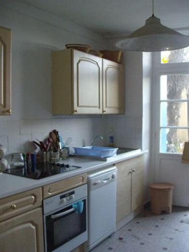 une cuisine avec un évier et une cuisinière four supérieur dans l'établissement Maison proche plages, tous commerces, à Arzon