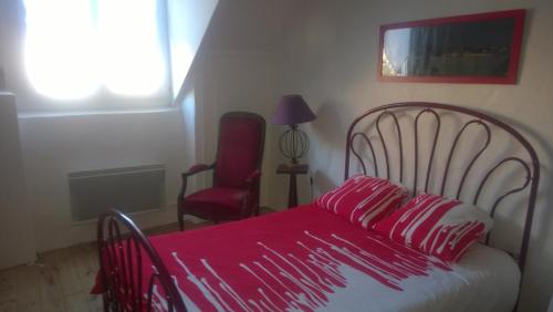 1 dormitorio con 1 cama con manta roja y silla en Maison proche plages, tous commerces, en Arzon