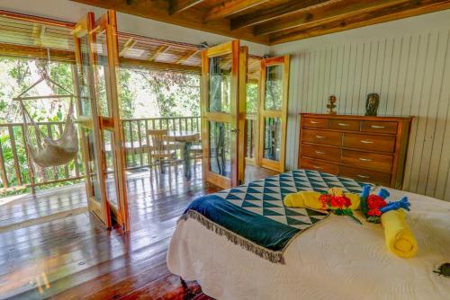 a bedroom with a bed and a balcony at Zimbali Culinary Retreats in Negril