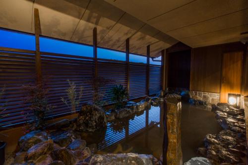 a room with a pool of water and a large window at Inishie no Yado Keiun in Izumo
