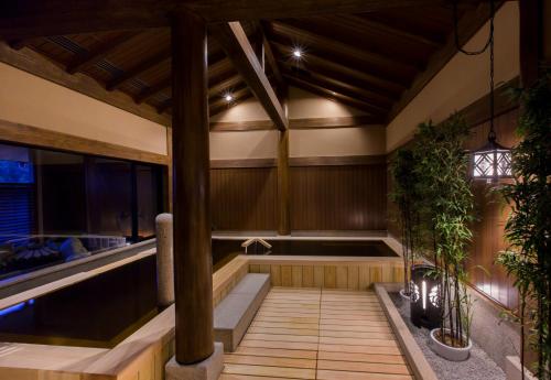 an outdoor sauna with a hot tub and plants at Inishie no Yado Keiun in Izumo