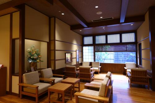 a waiting room with chairs and tables and a window at Inishie no Yado Keiun in Izumo