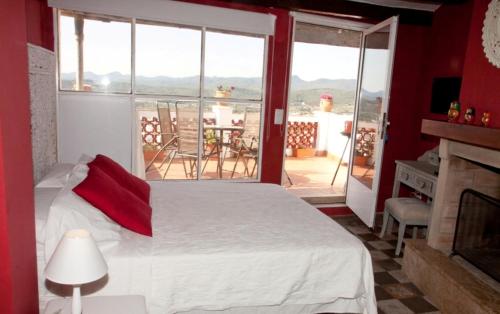 um quarto com uma cama e uma grande janela em Casa Rural Media Luna em Segorbe