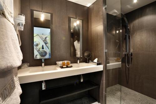 uma casa de banho com um lavatório e um chuveiro em Saint Georges Hotel & Spa em Chalon-sur-Saône