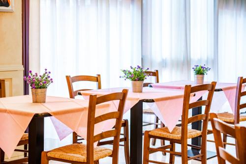 a room with tables and chairs with flowers on them at Continental Hotel in Lovere