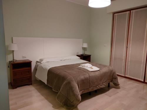 ein Schlafzimmer mit einem Bett, zwei Nachttischen und einem Tisch in der Unterkunft A CASA DI GIO' in Atri