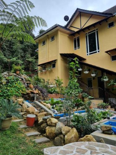 a garden in front of a house at Highlanders Garden Guesthouse at Arundina Cameron Highlands in Cameron Highlands